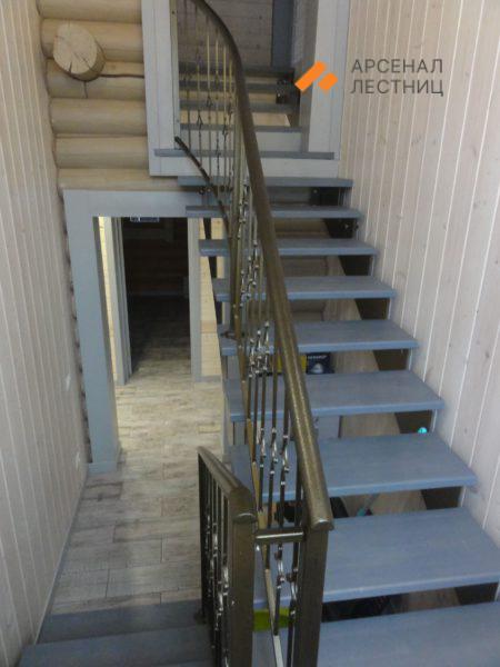 Лестница на ломаной тетиве с коваными перилами и деревянными крашеными ступенями. Зеленая роща